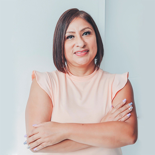 Mujer sonriendo, utilizando una blusa gris