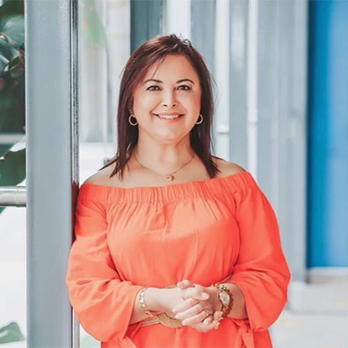 Mujer sonriendo, utilizando una blusa amarillo claro